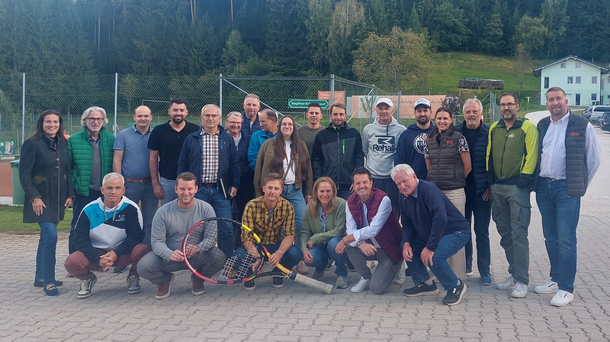 Tennisgruppe posiert vor Tennisplätzen in Österreich