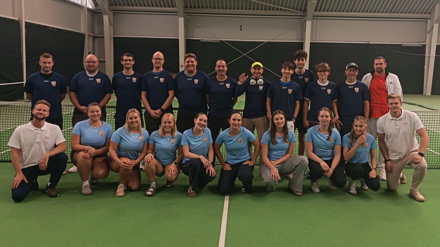 Tennis-Mannschaft mit Spielerinnen und Spielern auf einem Hallenplatz in Österreich